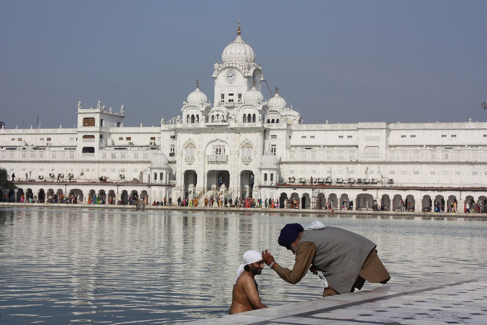 Golden Temple | Sikh Saints Pilgrims bathe in the Sarovar at the Golden Temple in Amritsar, a key site for Sikhism.